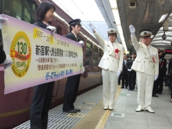 写真:130周年記念号の出発式をする吉住区長(左)