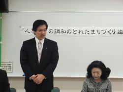 写真:「人と調和のとれたまちづくり連絡協議会」であいさつする吉住区長
