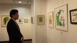 写真：蟹江杏さんの作品を見学する吉住区長（ヒルトピアアートスクエア）