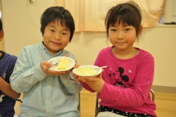 写真:向いたリンゴを手に笑顔の子どもたち