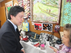 写真：手芸展示コーナーを視察する吉住区長