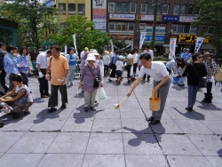 写真：吉住区長による打ち水