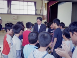 写真：児童と握手する吉住区長