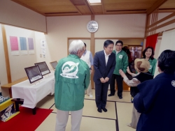 写真:展示ブースに関して説明を受ける吉住区長