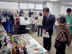 写真:展示ブースで説明を聞く吉住区長