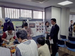 写真:リサイクル団体による説明を受ける吉住区長