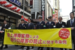 西新宿の一番街通りを横断幕を先頭にパレードする様子