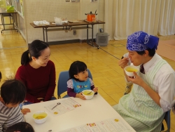 写真:参加者と一緒にスープを試食する吉住区長