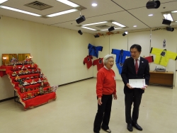写真:日本の遊びコーナーで説明を聞く吉住区長