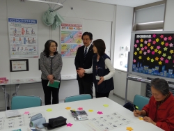 写真:保健師の説明を聞く吉住区長