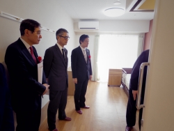 写真:ショートステイ用の個室を視察する吉住区長