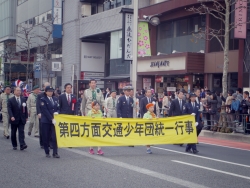 写真:横断幕とともにパレードする吉住区長