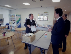 写真:防災食について説明をうける吉住区長