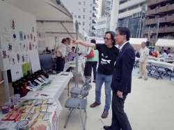写真:会場内ブースで説明を受ける吉住区長