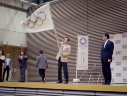 写真:オリンピックフラッグを振る釜本さん