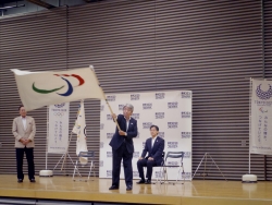 写真:パラリンピックフラッグを振る酒井教育長