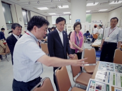 写真:参加団体から説明を受ける吉住区長