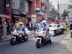 写真:パレードを先導する白バイとパトカー
