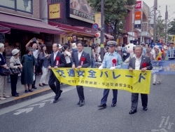 写真:横断幕を持ってパレードする吉住区長