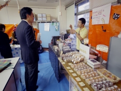 写真:ブースを回る吉住区長