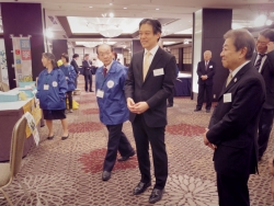写真:行政コーナー展示の説明を受ける吉住区長