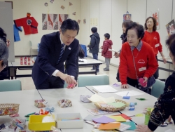 写真：日本の遊びコーナーを視察する吉住区長