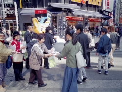 写真:啓発グッズを受け取る通行人