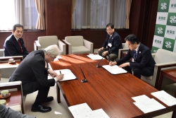 協定書にサインをする様子