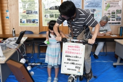 写真:発電自転車をこぐ来場者