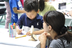 写真:出張児童館で親子が色塗りをしている様子