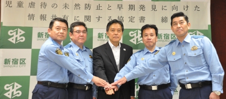 写真:手を1つに重ね、さらなる連携をアピールする吉住区長と四警察署長