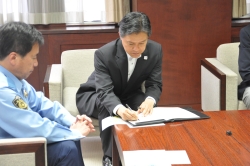 写真:協定書に署名する吉住区長