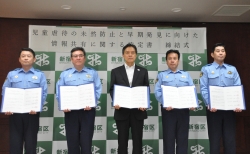 写真：協定書をそれぞれ手に持ち記念撮影をする吉住区長と四警察署長