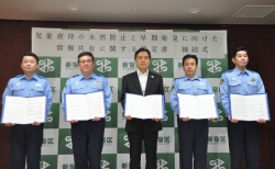 写真:協定書をそれぞれ手に持ち記念撮影をする吉住区長と四警察署長
