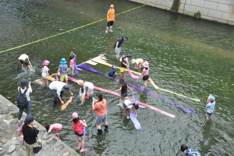 神田川親水テラスで染物を洗う染物体験者たち