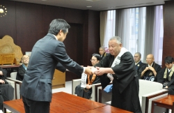 写真：佐々木会長から寄付金を受ける吉住区長
