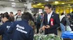 写真:中学生のブースで野菜を買う区長