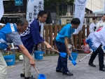 写真:打ち水をする区長