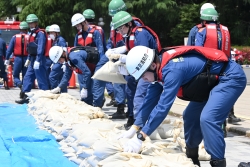 消防職員と消防団員が土のうを積み上げる様子