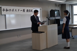 女子生徒が教育長から表彰状を受け取る様子の写真