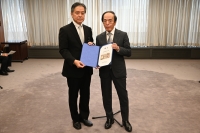 写真:日本銀行での贈呈式の様子(吉住区長と植田総裁が新紙幣を持って並んでいます)。